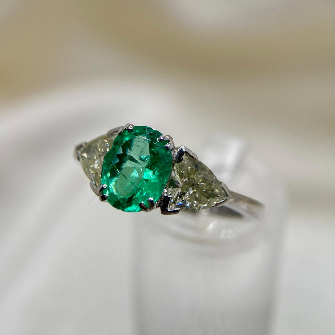 Linke Seitenansicht des Weißgoldrings, die elegante Krappenfassung des Smaragds und die seitlichen Diamanten zeigt.