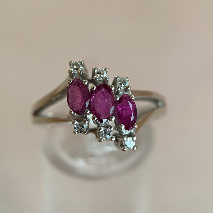 eißgoldener Ring 585 aus dem späten 20. Jahrhundert mit drei rubinroten Rubinen im Marquise‑Schliff und sechs funkelnden Achtkant‑Diamanten in Krappenfassungen, elegantes „Pinkes Wunder“‑Design