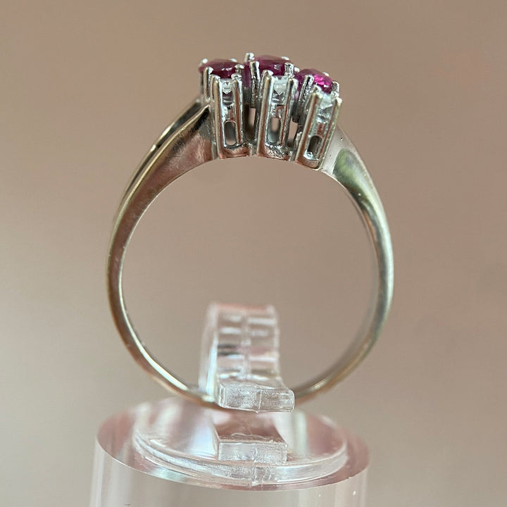 Seitenansicht des Rings mit Rubinen und Diamanten, betont Ringschiene, Profil und weiße Metalloberfläche