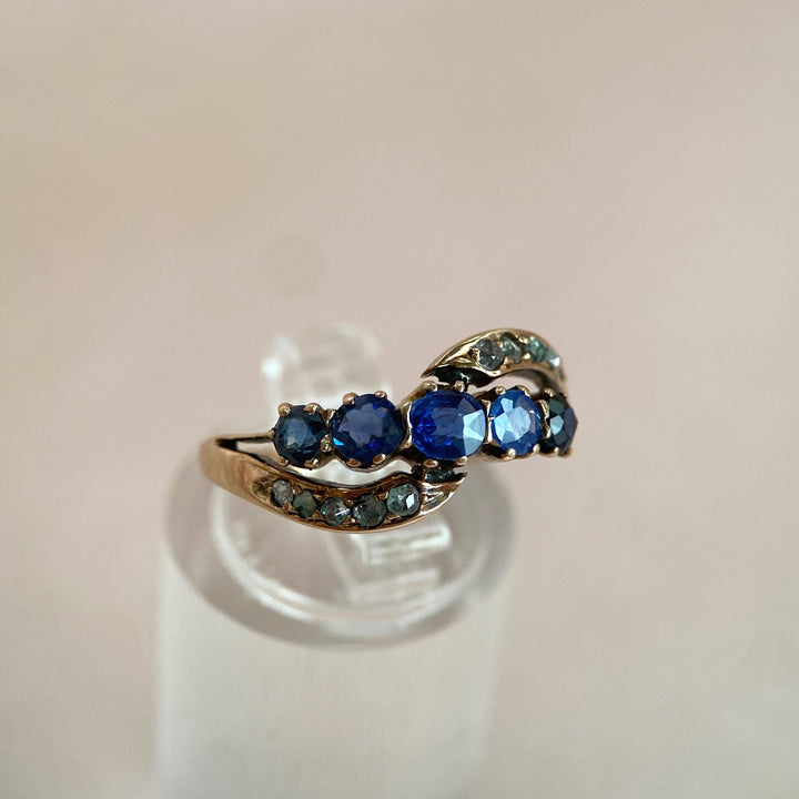 Detailaufnahme der fünf blauen Saphire im Vintage‑Ring, facettierte Edelsteine im Krappen‑ und ovalen Schliff sichtbar 
