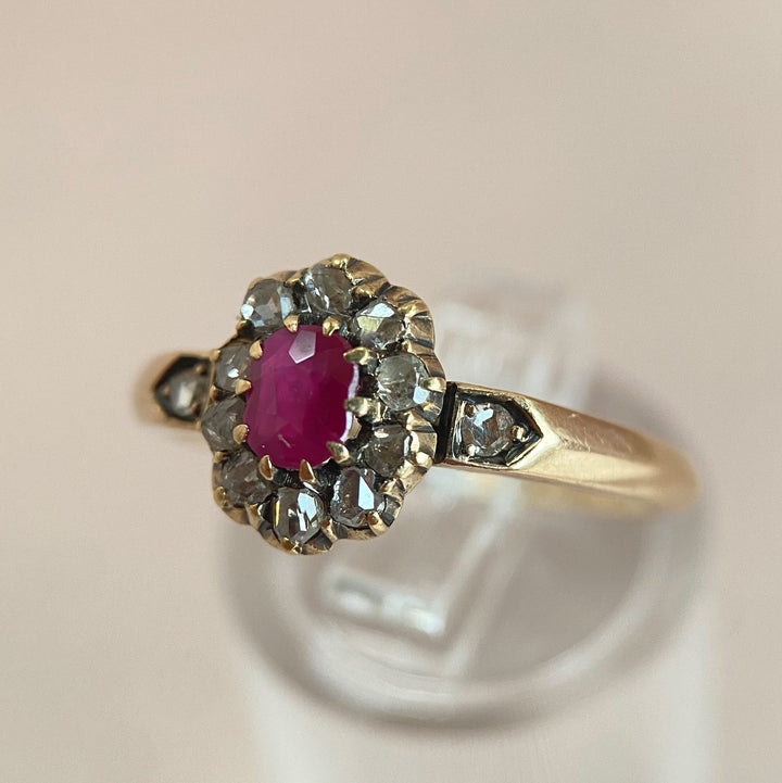 Nahaufnahme des intensiven roten Burma‑Rubins im antiken Gelbgoldring mit funkelnden Diamanten, Detailansicht