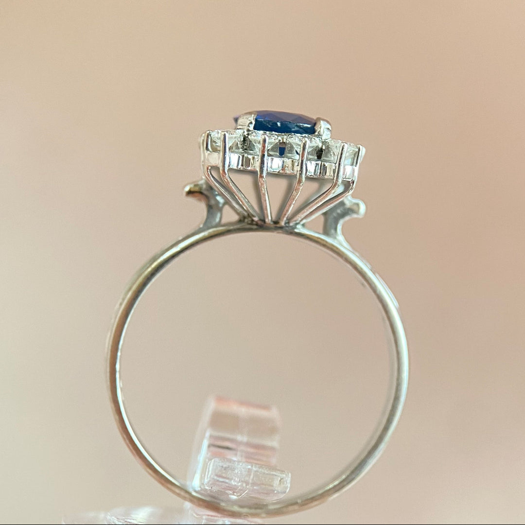 Seitenansicht des Rings mit Saphir und Diamanten, betont Ringschiene, Profil und elegante Weißgold‑Metallarbeit