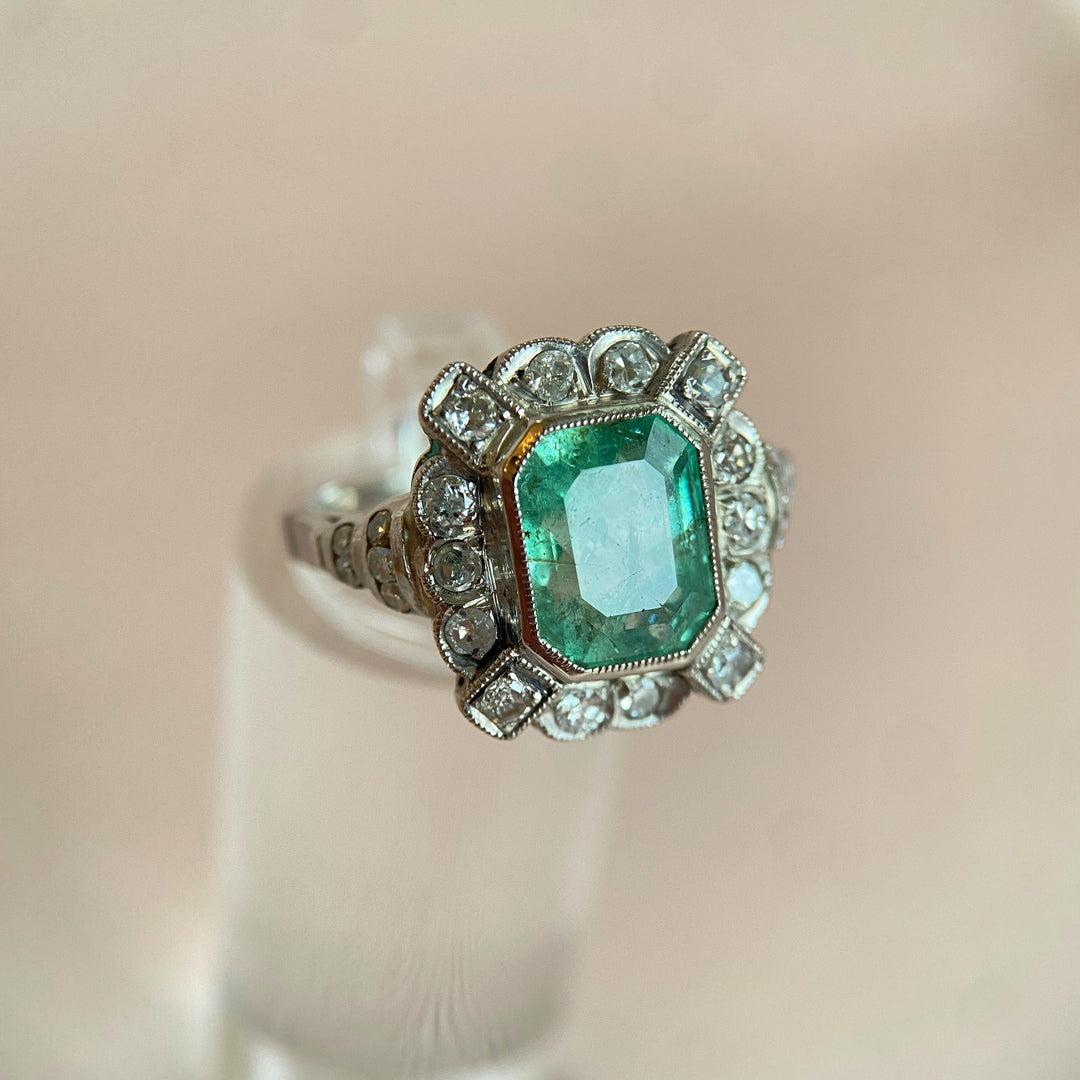 Nahaufnahme der Diamantenfassung im Platinring mit Smaragd, funkelnde Edelsteine und feine Handwerkskunst