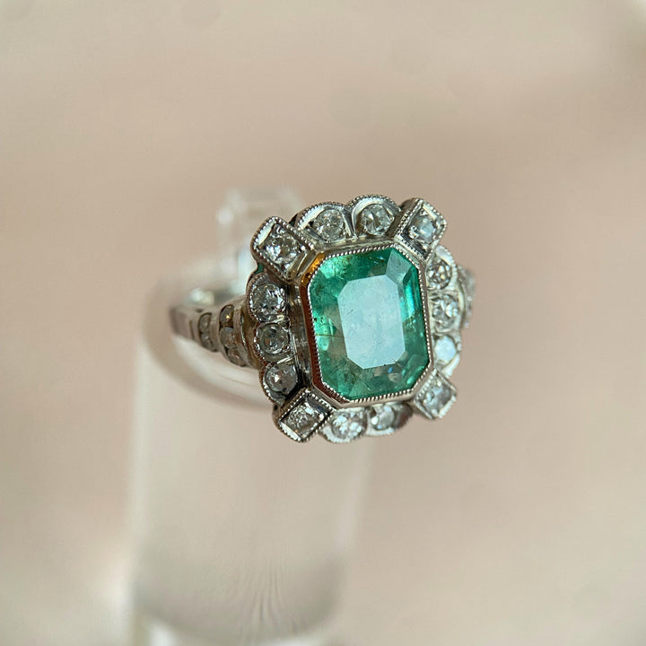 Nahaufnahme der Diamantenfassung im Platinring mit Smaragd, funkelnde Edelsteine und feine Handwerkskunst