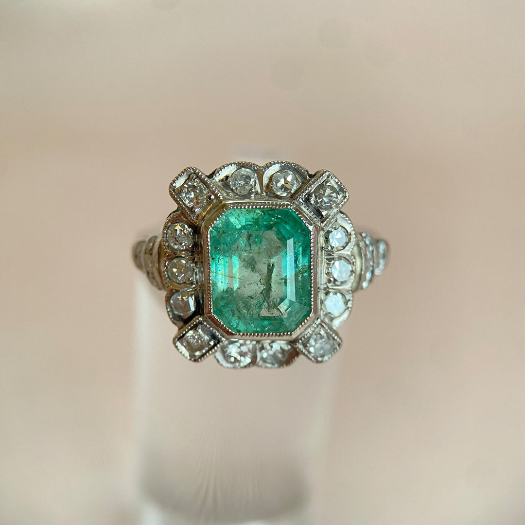 Detailaufnahme des facettierten Smaragds im Platinring mit Diamanten, kräftiges Grün und präzise Fassung sichtbar