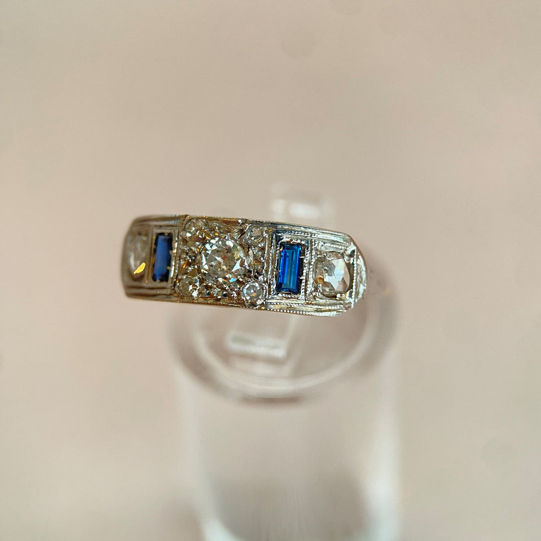 Studioaufnahme des Weißgoldrings mit Lichtreflexen auf Edelsteinen, betont Brillanz und Goldoberfläche seitlich