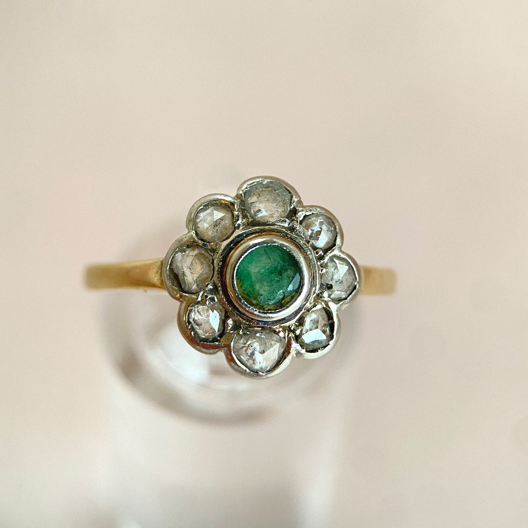 Eleganter Vintage‑Weißgoldring mit grünem Smaragd und funkelnden Diamanten, klassisches Schmuckstück mit zeitloser Romantik