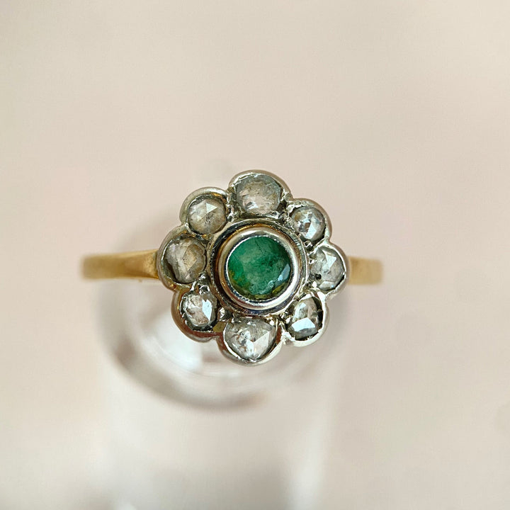 Eleganter Vintage‑Weißgoldring mit grünem Smaragd und funkelnden Diamanten, klassisches Schmuckstück mit zeitloser Romantik