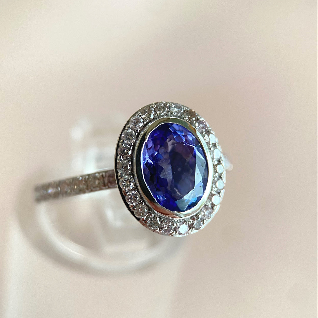 Nahaufnahme der 38 Diamanten im Rundschliff um den Tanzanit, feine Kornfassungen und funkensprühende Edelsteine