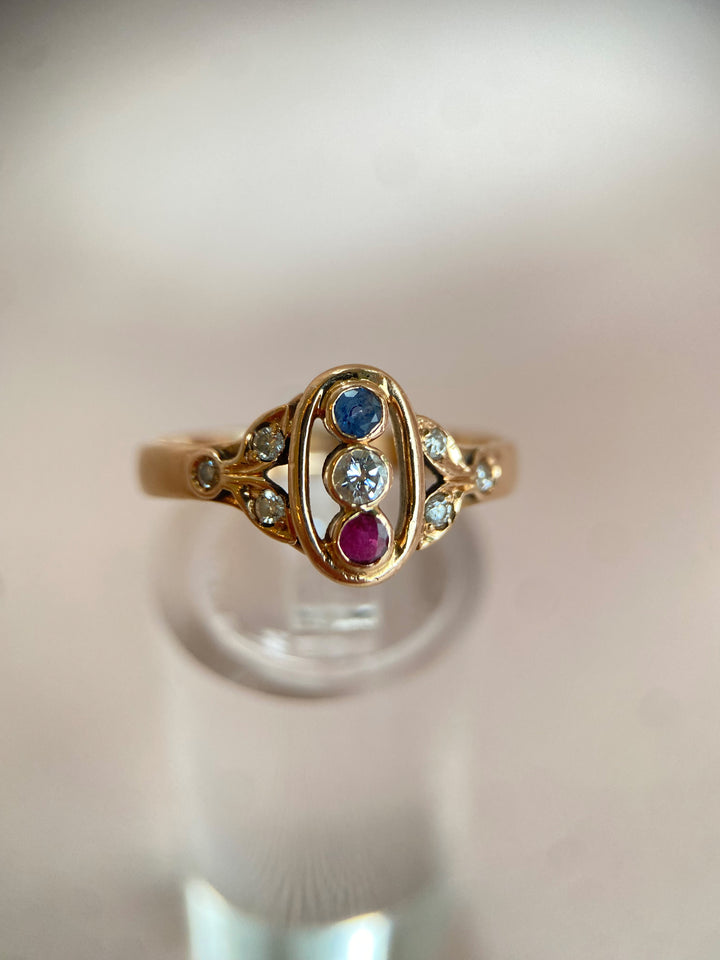 Detailaufnahme des leuchtend roten Rubins im Zargengoldring mit Diamanten und Saphir, intensive Farbwirkung erkennbar