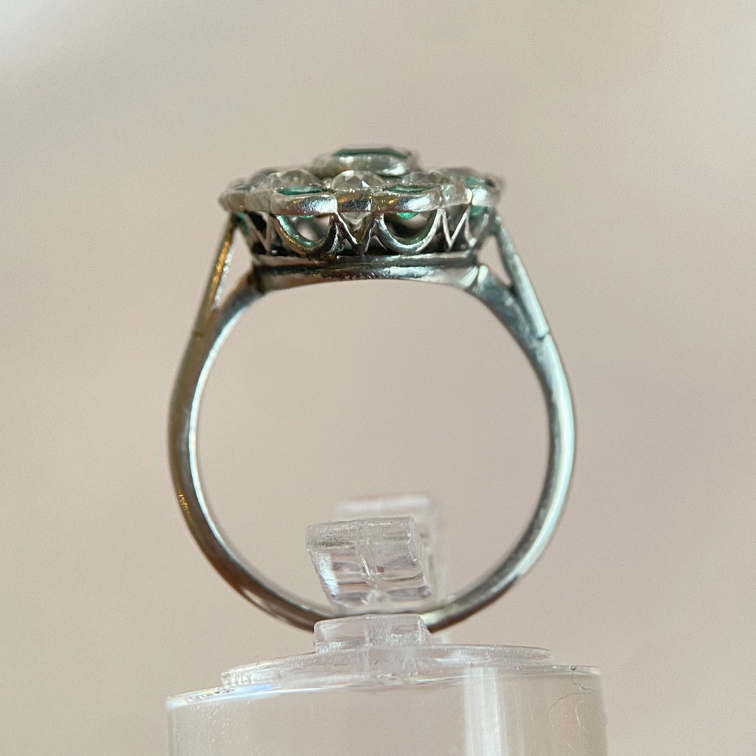 Gesamtansicht des Platin-Smaragd-Diamant-Rings auf neutralem Hintergrund, edles Vintage-Schmuckstück 
