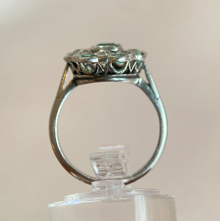 Gesamtansicht des Platin-Smaragd-Diamant-Rings auf neutralem Hintergrund, edles Vintage-Schmuckstück 
