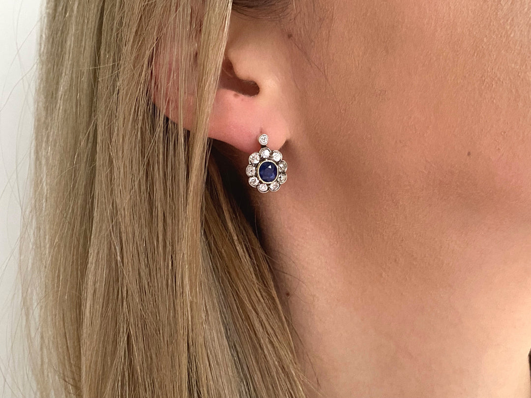 Tragefoto: Saphir- und Diamant-Ohrringe aus Gelb- und Weißgold getragen am Ohrläppchen, zeigt elegante Wirkung und Proportionen