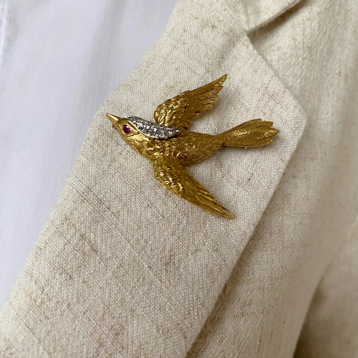 Tragefoto: Vintage‑Goldbrosche mit Rubin und Diamanten am Revers getragen, zeigt elegante Wirkung und Proportionen