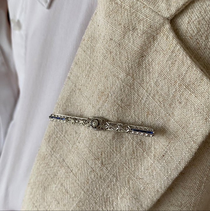 Tragefoto: Weißgold‑Brosche mit Diamanten und synthetischen Saphiren am Revers getragen, elegante Wirkung sichtbar