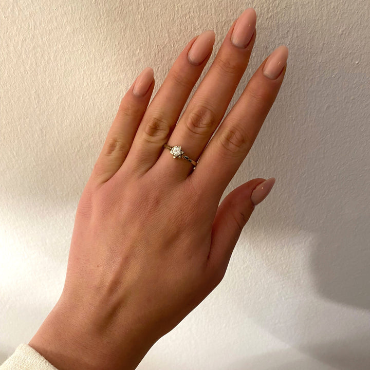 Tragefoto: Vintage Weißgoldring mit 0,25 ct Diamant in Krappenfassung am Finger getragen, zeigt Größe und elegante Wirkung