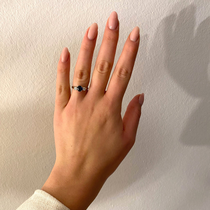 Tragefoto: Ring aus den 1990ern mit blauem Saphir und Diamanten am Finger getragen, zeigt Eindruck und Proportion