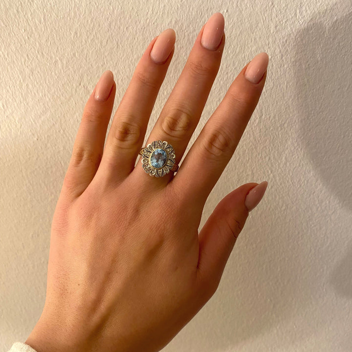 Tragefoto: Gelbgoldring mit blauem Topas und Diamanten am Finger getragen, Wirkung und Stil des Rings