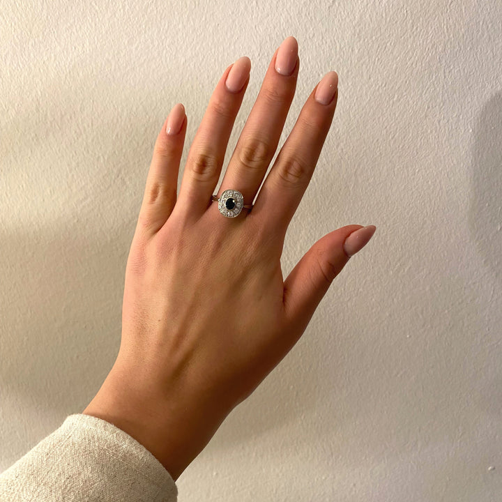 Tragefoto: Weißgoldring mit blauem Saphir und Diamanten am Finger getragen, elegant und zeitlos wirkend