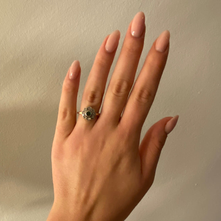 Tragefoto: Vintage‑Weißgoldring mit Smaragd und funkelnden Diamanten am Finger getragen, zeigt Größe und edle Wirkung