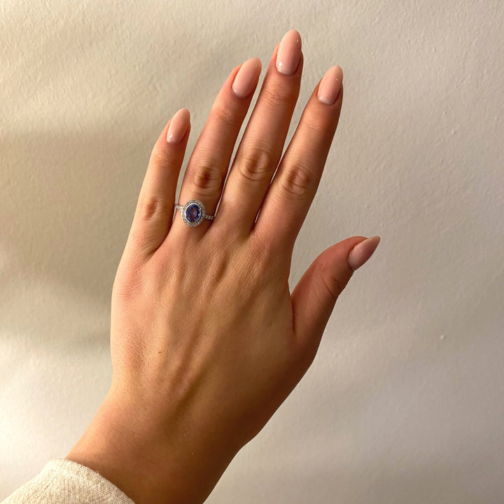 Tragefoto: Weißgold‑Tanzanit‑Diamant‑Ring am Finger getragen, elegant und stilvoll wirkend 
