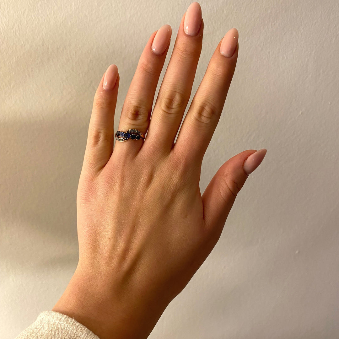 Tragefoto: Vintage‑Ring mit blauen Saphiren und Diamanten am Finger getragen, zeigt Größe und elegante Wirkung