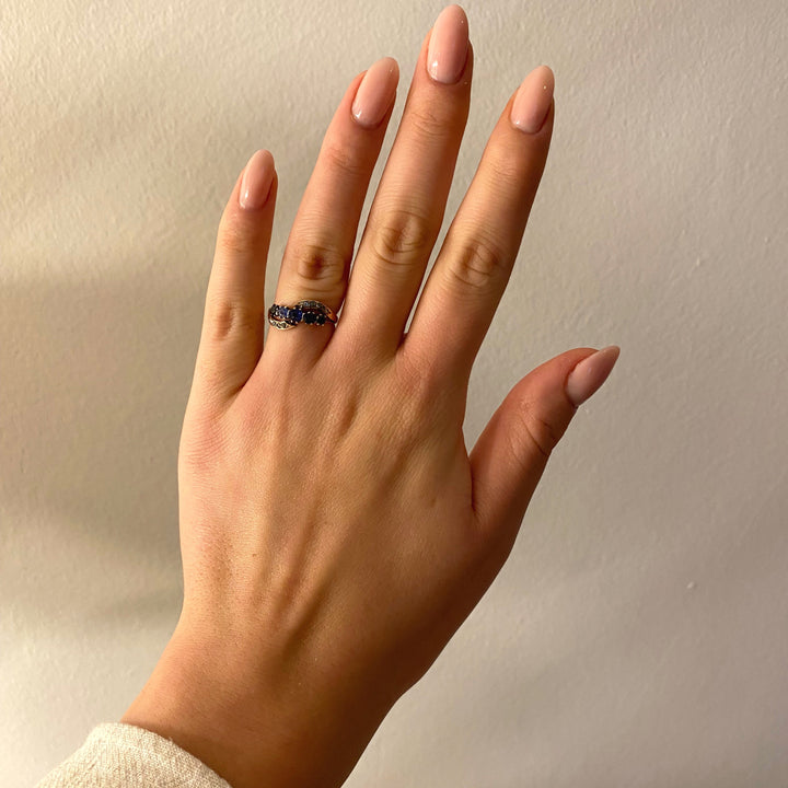 Tragefoto: Vintage‑Ring mit blauen Saphiren und Diamanten am Finger getragen, zeigt Größe und elegante Wirkung
