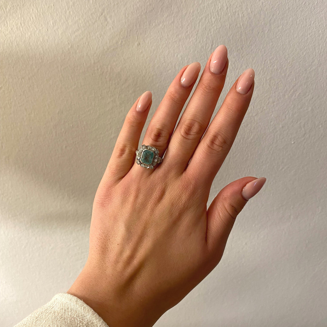 Tragefoto: Platinring mit Smaragd und Diamanten am Finger getragen, Wirkung und Stil des Schmuckstücks