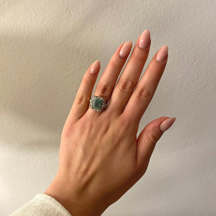 Tragefoto: Platinring mit Smaragd und Diamanten am Finger getragen, Wirkung und Stil des Schmuckstücks