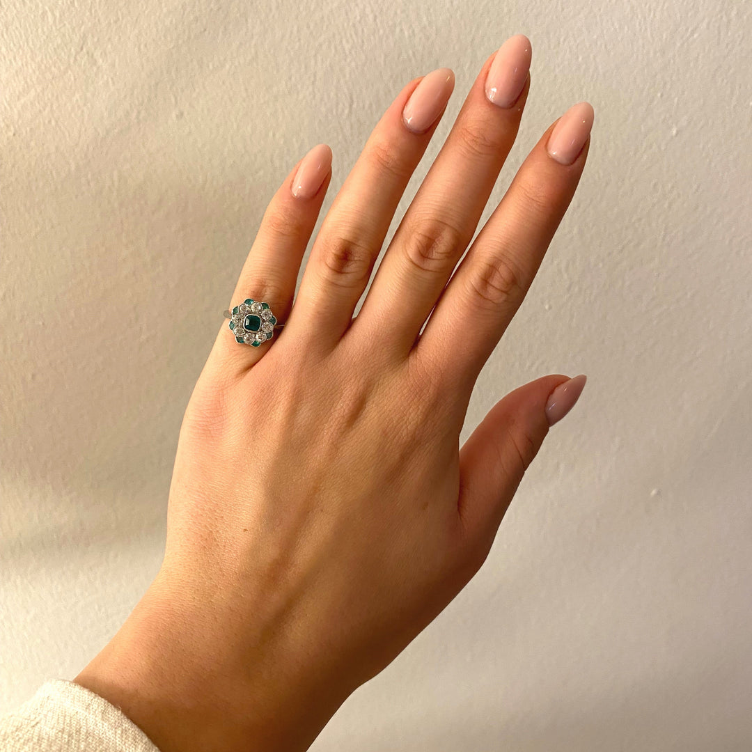 Tragefoto: Antiker Platinring mit Smaragden und Diamanten am Finger getragen, zeigt Größe und Eleganz