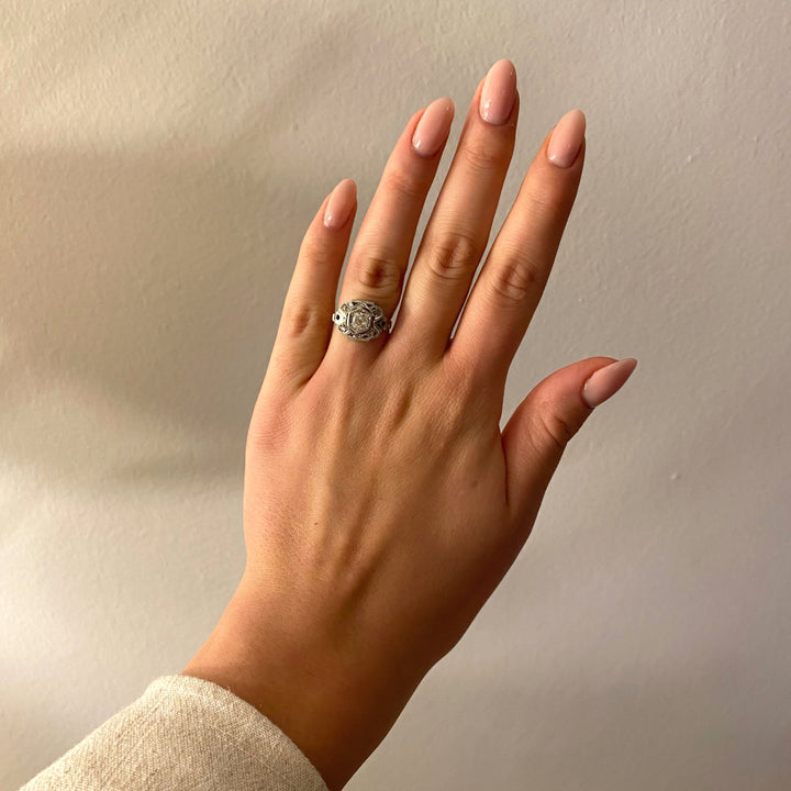 Tragefoto: Historischer Weißgoldring mit Diamanten in Kornfassungen am Finger getragen, zeigt Größe und elegante Wirkung