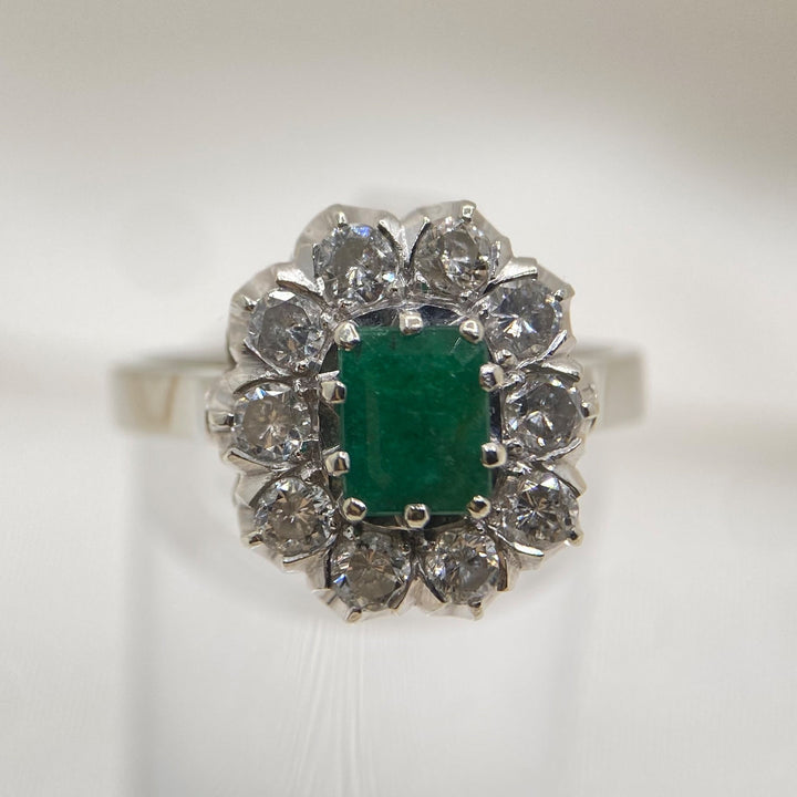 Vintage Weißgoldring 585 mit grünem achtkant‑Smaragd ca. 0,75 ct und zehn funkelnden Diamanten im Rundschliff, klassisches „Lädiertes Zauberwerk“‑Design aus der Mitte des 20. Jahrhunderts