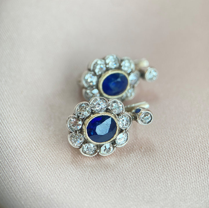 Detailaufnahme der tiefblauen facettierten Saphire in Zargenfassungen der Gelbgold-Weißgold-Ohrringe, kräftiger Farbton erkennbar