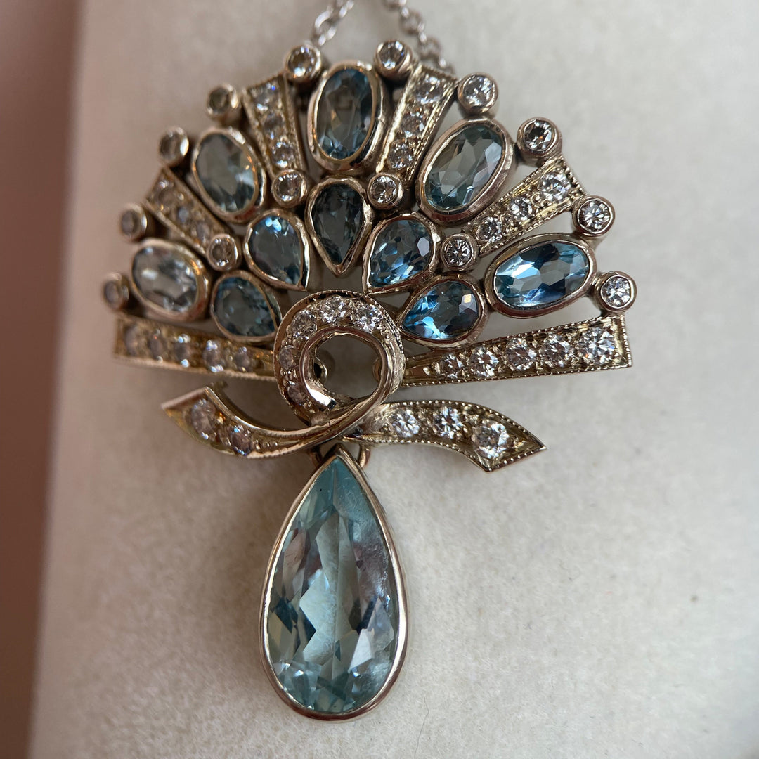 Studiofoto mit Lichtreflexen auf Aquamarin und Brillanten, betont Farbspiel und Glanz der Materialien