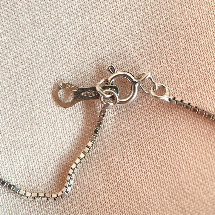 Detailfoto des Weißgold‑Clip‑Mechanismus und feiner Handwerksarbeit im Anhänger‑Design