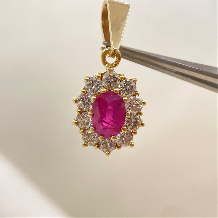 Anhänger aus 585er Gelbgold mit facettiertem Rubin im Ovalschliff und zehn Brillanten in Krappenfassungen.