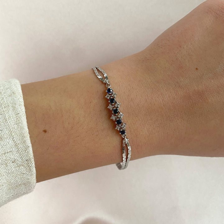 Gesamtansicht – Weißgoldarmband mit fünf blauen Saphiren im Rundschliff und acht Diamanten im Achtkantschliff, harmonisch gefasst.