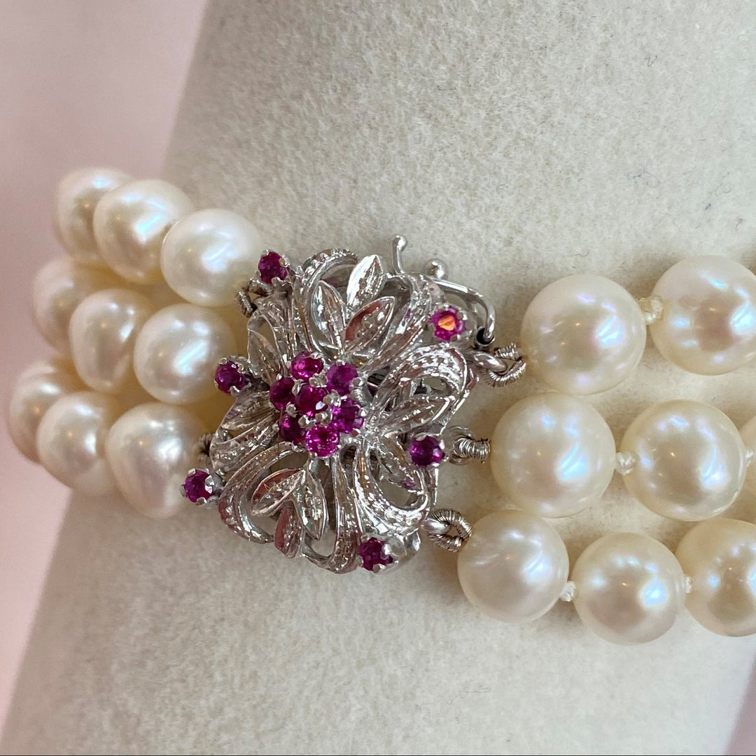 Nahaufnahme der rund facettierten Saphire in violett-rötlichen Farbtönen mit feinen Krappenfassungen.