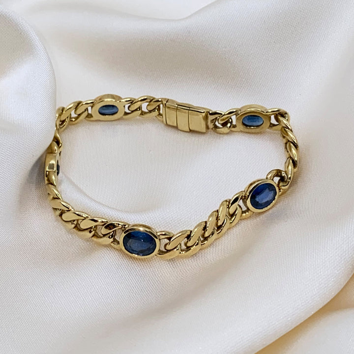 Gesamtansicht – Armkette aus 750er Gelbgold mit fünf facettierten blauen Saphiren in Kastenfassungen.