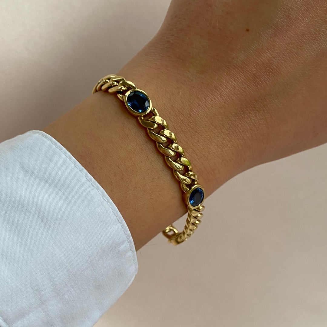 Getragen – Gelbgold-Armkette mit Saphiren am Handgelenk, luxuriöse Präsenz und harmonische Proportion.