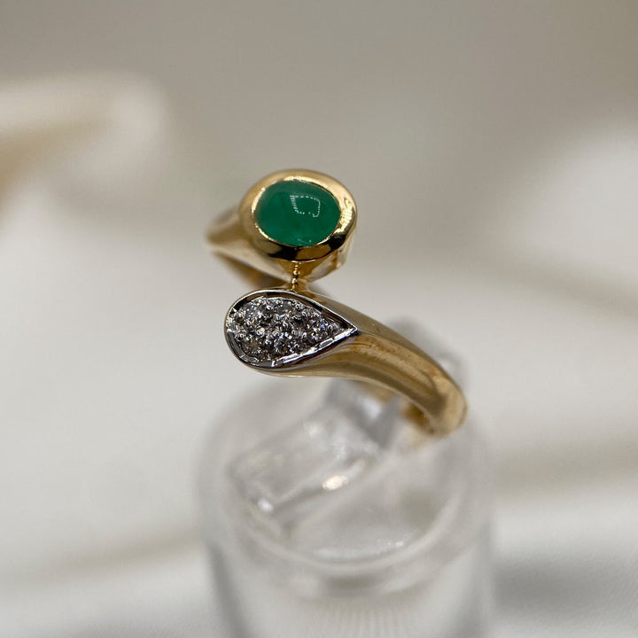 Ring aus 585er Gelbgold mit ovalem Smaragd im Cabochonschliff und fünf Diamanten im Brillantschliff.