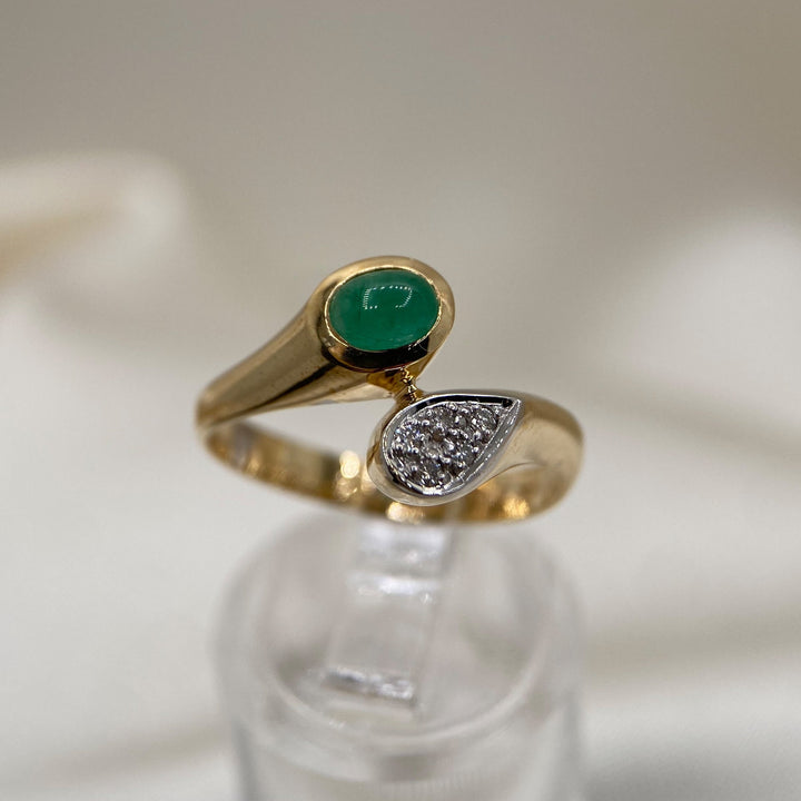 Detailaufnahme des smaragdgrünen Cabochons mit begleitenden Diamanten im runden Brillantschliff.