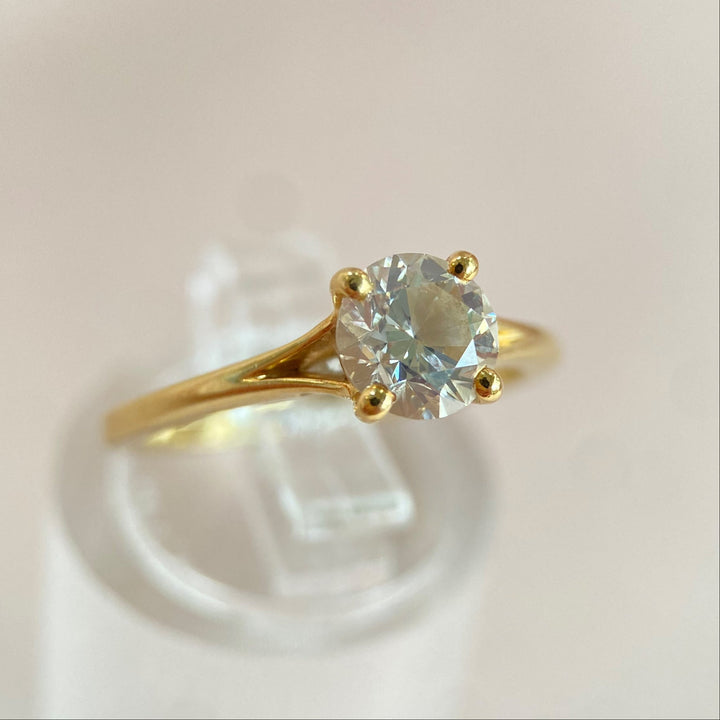 Rechte Seitenansicht des hochglanzpolierten 18-Karat-Gelbgoldrings mit präzise gefasstem Brillanten.