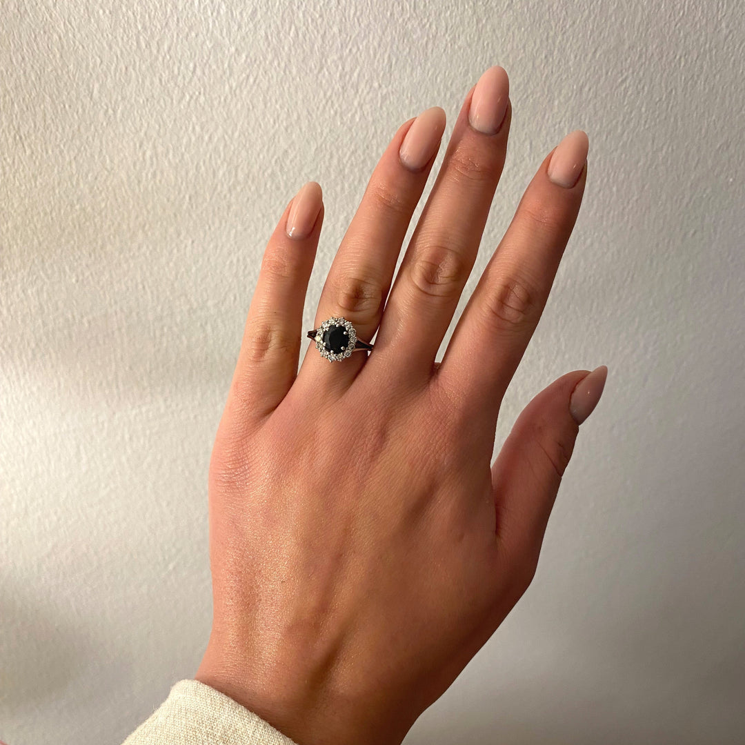Weißgoldring 750 mit dunkelblauem Saphir und Diamanten am Finger getragen