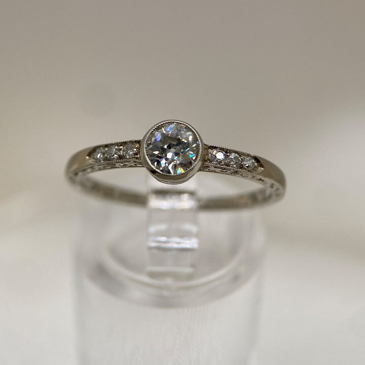 Vintage-Weißgoldring aus den 1930er–1950er Jahren mit einem Diamanten im Old European Cut und sechs Achtkantdiamanten in Zargen- und Körnerfassungen.