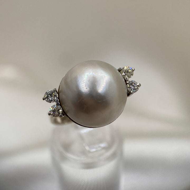 Weißgoldring aus 585er Gold mit zentraler Mabe-Zuchtperle und vier Diamanten in klassischer Krappenfassung.