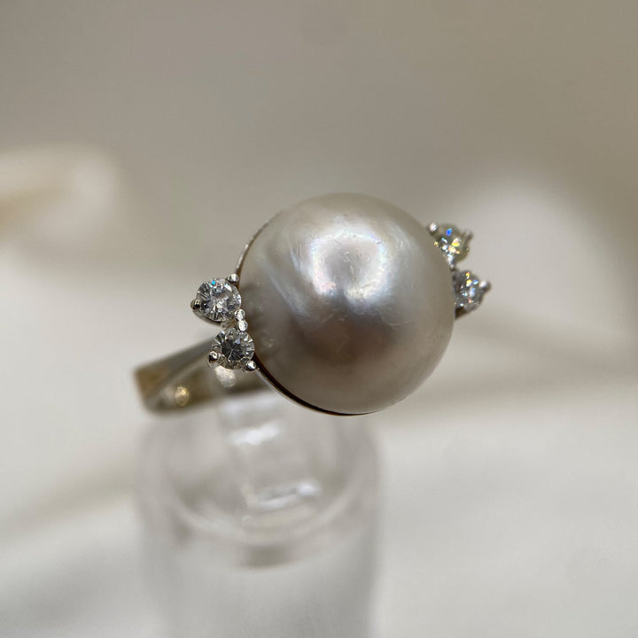 Rechte Seitenansicht des 585er Weißgoldrings, die Diamantfassungen und den sanften Lüster der Mabe-Perle zeigt.