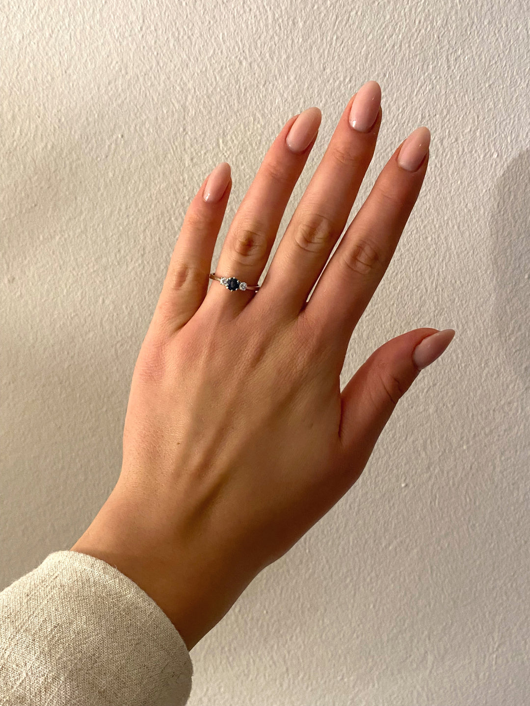 Weißgoldring mit Saphir und Diamanten am Finger getragen, moderner eleganter Stil