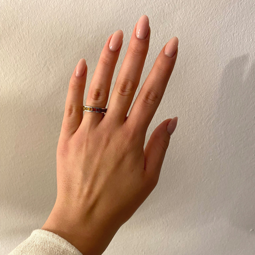 Getragener Weißgoldring mit farbigen Saphiren – kraftvolle Farbwirkung und moderne Linienführung am Finger.