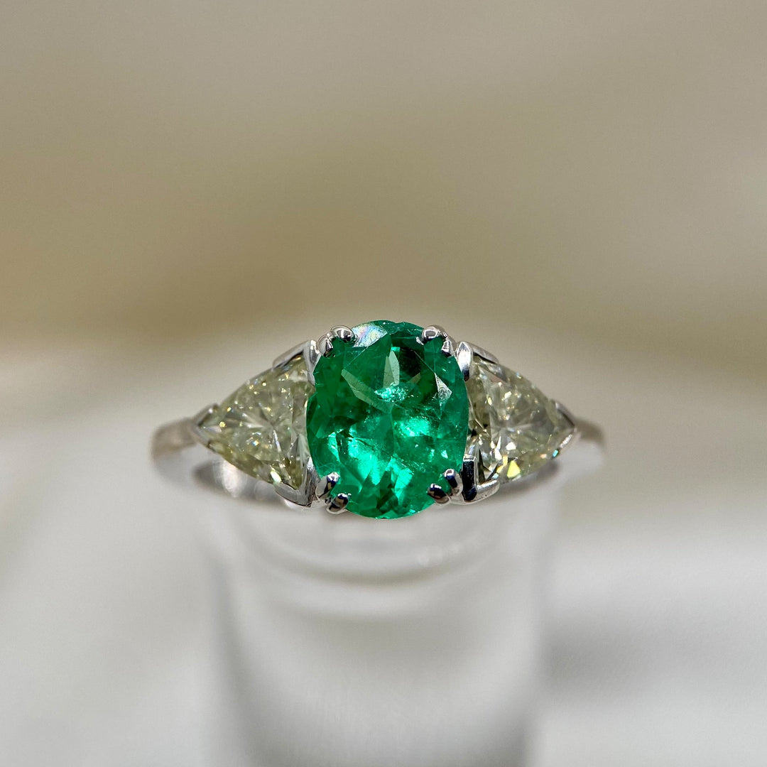 Nahaufnahme des Smaragds mit moderater Klarheitsverbesserung und flankierenden Diamanten im Trilliant-Schliff.